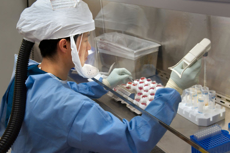 This 2013 image depicts a Centers for Disease Control and Prevention (CDC) scientist harvesting H7N9 virus, grown for the purpose of sharing with partner laboratories for research purposes.